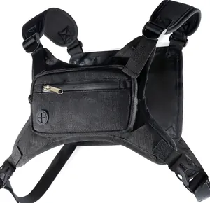 Detail of tactical chest bag showing adjustable X-straps and cable port on black nylon