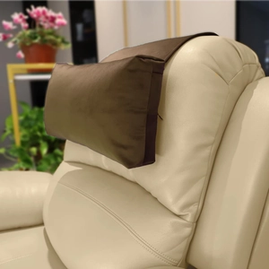 Detail view of deep brown velvet recliner headrest with anti-slip base on leather sofa