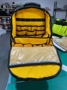 Detailed interior of a heavy duty tool backpack with yellow lining and mesh pockets