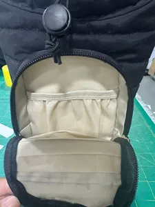 Detail showing inner compartments with elastic bands and beige lining of the black bag