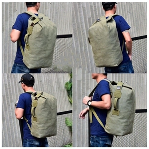 Macro detail of large olive green canvas travel backpack with reinforced handles