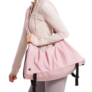 Borsa fitness rosa impermeabile con texture setosa e tracolla indossata da una modella