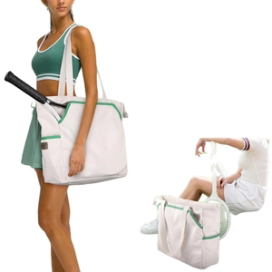 White canvas tennis tote bag with green trim and dedicated racket pocket for sports use