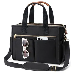 Detail view of black canvas tote bag showing front pockets for sunglasses and phone