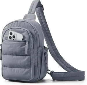 Close-up of a quilted grey crossbody bag with a smartphone inside the front zipper pocket