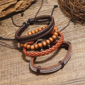 Vintage braided leather bracelet set for men featuring wooden beads on a rustic wood background