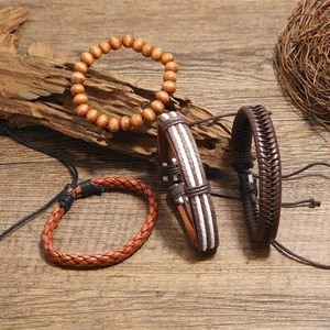 Set of four vintage braided leather and wooden bead bracelets for men on a wood background