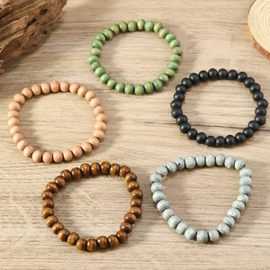 Close-up of five handmade bohemian wooden bead bracelets in natural earthy tones and textures