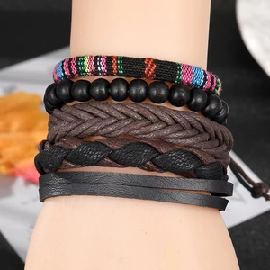Détail de cinq bracelets bohèmes superposés avec cordon tressé et perles en bois