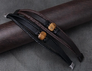 Dettaglio di bracciali in pelle da uomo con occhio di tigre e chiusura magnetica nera