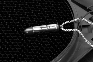 Detailopname van een zilveren kogelhanger met kruisgravure en stevige vierkante ketting