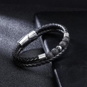 Macro shot of double-layer black braided leather bracelet with lava stone beads and magnetic clasp