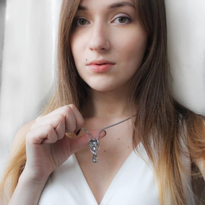 Collier urne ailes d'ange en acier inoxydable argenté sur mannequin femme