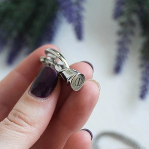 Vue macro d'un pendentif urne cylindrique en acier inoxydable avec bouchon à vis