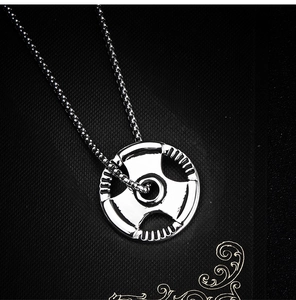 Macro detail of a silver barbell plate pendant featuring an industrial box chain design