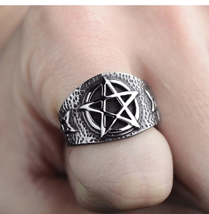 Macro detail of vintage punk star ring with hammered texture and oxidized steel finish