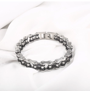 Detail view of silver industrial motorcycle chain bracelet with folding clasp on white fabric