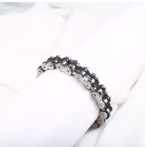 Detailed view of silver stainless steel motorcycle chain bracelet on white silk background