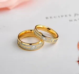 Gros plan sur les bagues de couple en acier brossé avec gravure Forever Love et cristal