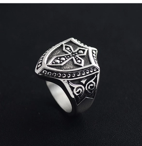 Macro shot of retro shield ring featuring a carved cross and vintage silver finish