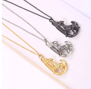 Three polished stainless steel dog urn pendants in black, silver, and gold finishes