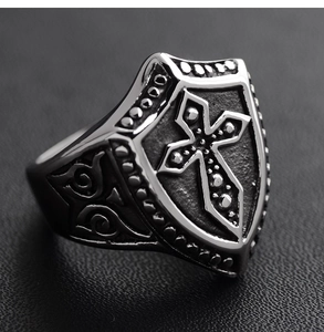 Detailed macro view of retro shield ring with embossed cross and black oil finish