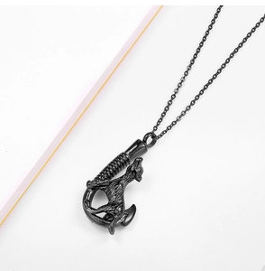 Detail of black wolf head and fish hook pendant with engraved texture on a steel chain