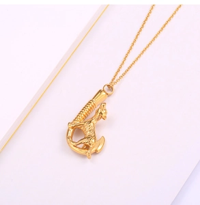 Detail of a golden stainless steel wolf fishhook necklace pendant on a white background