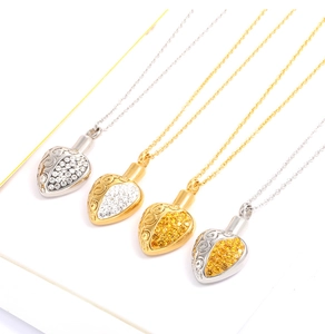 Macro detail of heart-shaped perfume urn necklaces in silver and gold with crystals