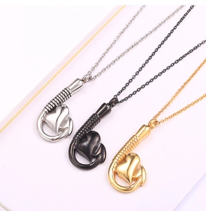 Dettaglio di ciondoli profumo a forma di cuore e amo in argento, oro e nero
