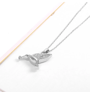 Macro shot of silver hummingbird cremation urn necklace with detailed feather textures