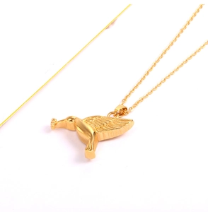 Detailed close-up of a golden bird-shaped perfume bottle pendant on a fine link chain