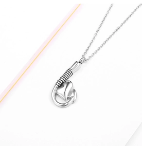 Dettaglio del ciondolo a cuore e amo d'argento con trama filettata su collana in acciaio lucido