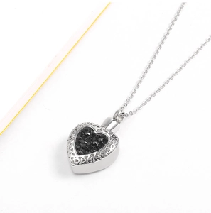 Dettaglio del ciondolo a cuore argento con cristallo nero e trame filigranate vintage