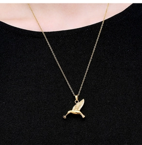 Detailed view of hummingbird perfume bottle pendant in gold finish on neck