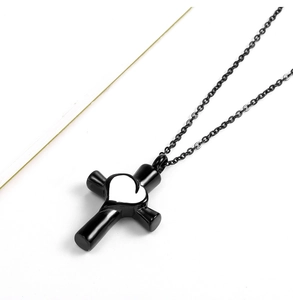 Dettaglio della collana a croce nera in acciaio inossidabile con un cuore in argento