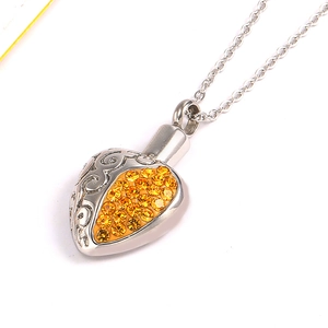 Pendentif cœur en acier inoxydable avec cristaux jaunes et gravures florales sur chaîne croisée