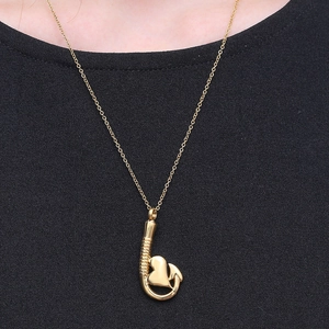 Collana con ciondolo a cuore a forma di amo in oro lucido su catena minimalista da donna