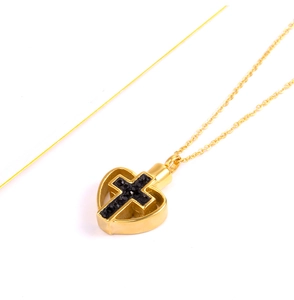 Makroaufnahme Gold Herz-Kreuz-Urnenanhänger mit funkelnden schwarzen Steinen