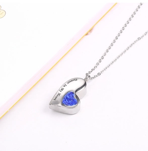 Macro shot of silver heart urn necklace with blue crystals and Forever In My Heart text