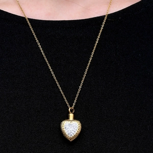 Collier flacon de parfum cœur doré avec cristaux et motifs vintage en relief élégant