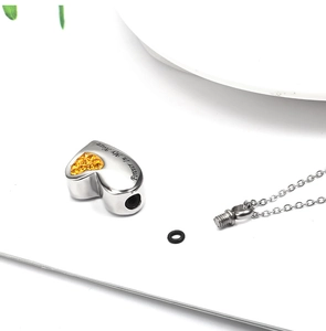 Detail of heart perfume bottle necklace showing Forever In My Heart engraving and screw opening