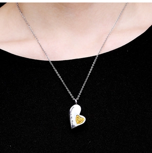 Silver heart urn necklace for ashes with Always In My Heart engraving on a black shirt