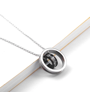 Detail of silver and black stainless steel double ring necklace with engraved Spanish scripture