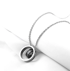 Detailed macro view of double ring necklace with cross and engraved Spanish religious prayer