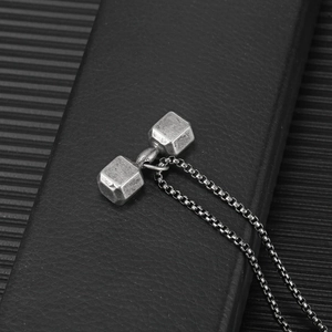 Vue macro d'un collier pendentif haltère vintage avec une texture métallique industrielle