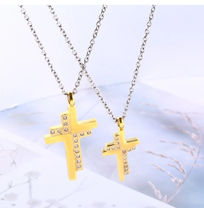 Detailed view of polished gold cross pendants with small diamonds on silver chains