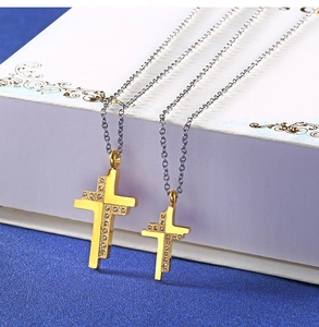 Detail of gold cross pendant necklaces with sparkling rhinestones on an elegant gift box