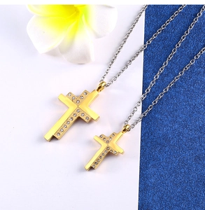 Detailed view of gold cross pendants with diamond inlay on stainless steel chains