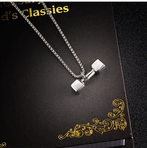 Pendentif haltère poli avec chaîne box sur fond de boîte cadeau noire élégante